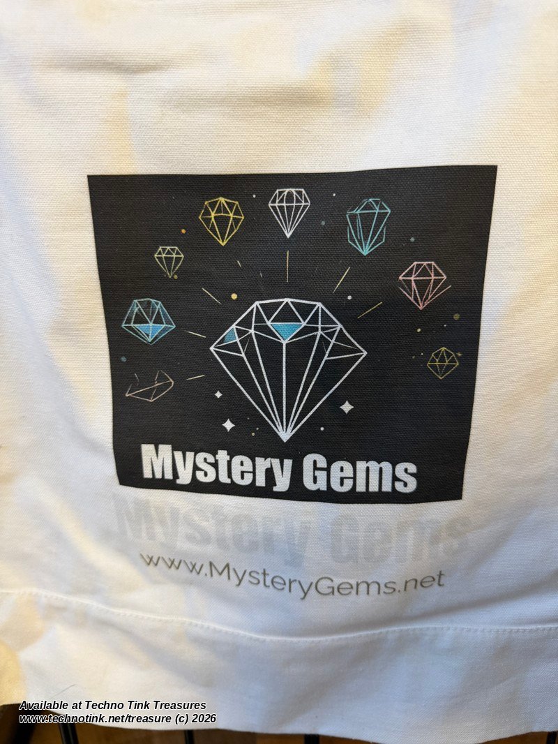 Close-up of the Mystery Gems diamond logo and MysteryGems.net on the white canvas tote
